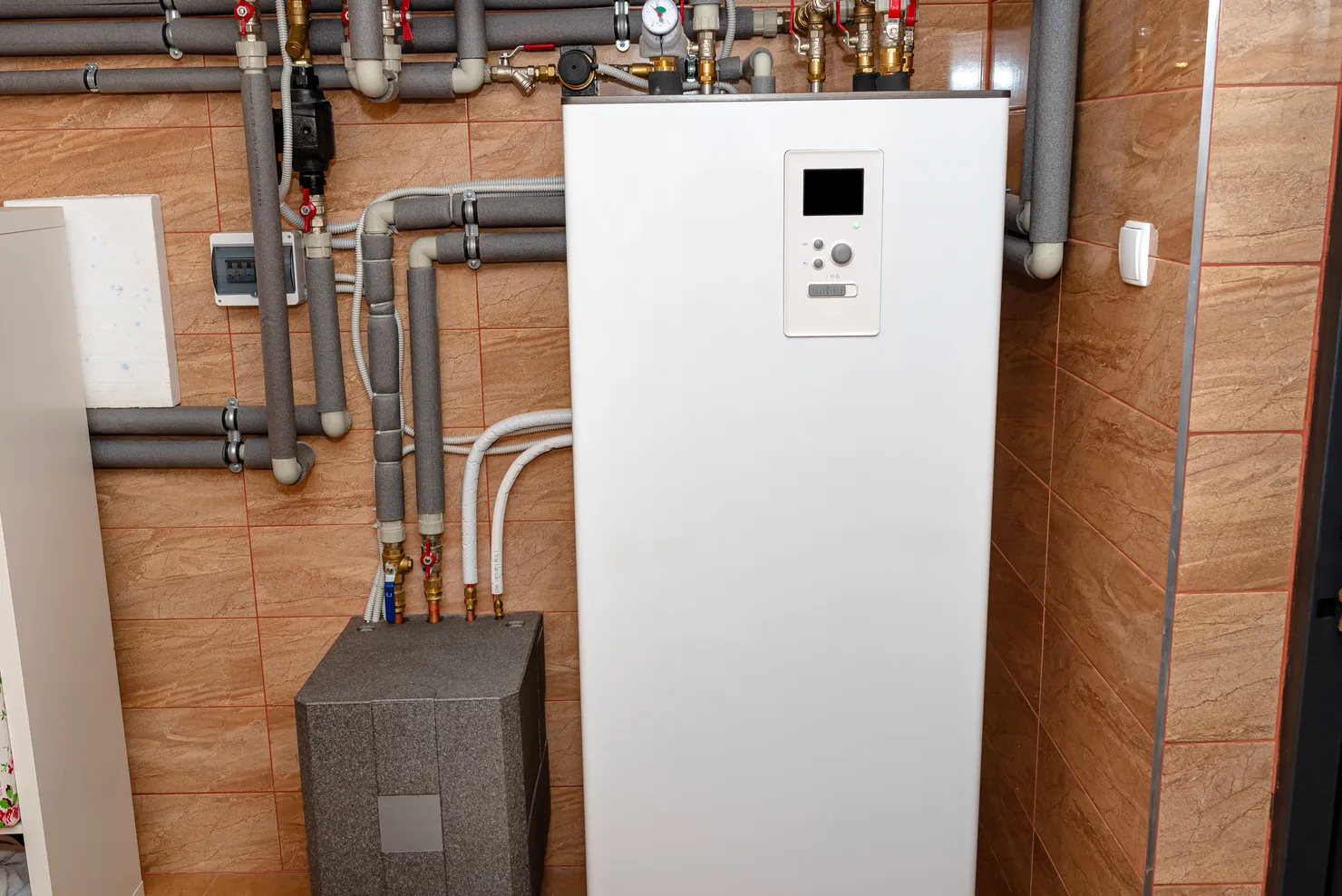 Indoor ground source heat pump unit and manifold pipework in a domestic plant room
